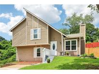 Charming split-level home featuring a unique roofline, neutral siding, and well-maintained landscaping at 1126 Mainstreet Valley Dr, Stone Mountain, GA 30088