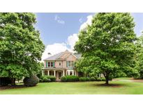 Charming brick home with lush green lawn and mature trees providing shade and curb appeal at 4045 Hillcrest View Ct, Suwanee, GA 30024