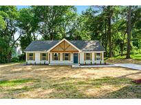 Charming single-story home with board and batten siding, gable pediment, and a lush green lawn at 124 Sims Dr, Hiram, GA 30141