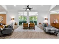Bright living room features modern furnishings, gray couches, ceiling fan, and outdoor patio view at 2349 Echo Cliff Ne Ct, Atlanta, GA 30345