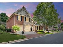 Charming two-story home with brick and stone exterior, a two-car garage, and a well-manicured lawn at 255 Wembley Cir, Atlanta, GA 30328