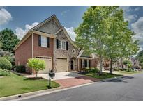 Charming brick home with a two-car garage, complemented by a lush green lawn and mature trees at 255 Wembley Cir, Atlanta, GA 30328