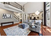 Bright living room with hardwood floors, gray sofa, high ceilings and a large rug at 302 Shawnee Indian Ln, Suwanee, GA 30024