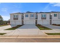 New townhomes with white exteriors, gray accents, and individual driveways under a bright sky at 332 Heavenly Hollow Pl, Mcdonough, GA 30253