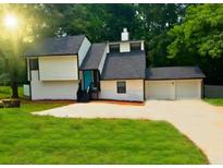 View of a charming two-story home with an attached two-car garage and a well-manicured lawn at 4411 Flakes Mill Rd, Ellenwood, GA 30294