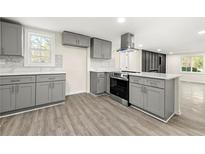 Modern kitchen with gray cabinetry, stainless steel appliances, island, and stylish countertops at 2331 Luther St, Lithonia, GA 30058