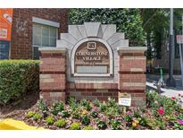 A sign at Cornerstone Village Historic Lofts & Condominiums with beautiful flowers and landscaping at 800 Peachtree Ne St # 1504, Atlanta, GA 30308