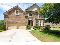 Elegant brick and stone home with a well-manicured lawn and a three-car garage at 344 Nottingham Dr, Marietta, GA 30066
