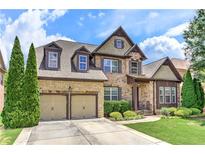 Charming two-story home featuring a stone and brick facade, manicured lawn, and a two-car garage at 4924 Locklear Way, Marietta, GA 30066