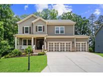 Charming two-story home features a spacious three-car garage, manicured lawn, and inviting front porch, perfect for suburban living at 6045 Stargazer Way, Cumming, GA 30028