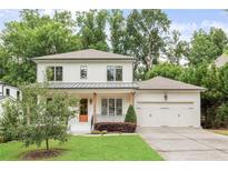 Charming two-story home features a manicured lawn, covered porch with wood accents and a two car garage at 2602 Drew Valley Ne Rd, Brookhaven, GA 30319