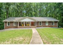 Ranch style home with red brick, white columns, walkway, and a well-manicured lawn at 1310 Chilton Woods Rd, Rutledge, GA 30663