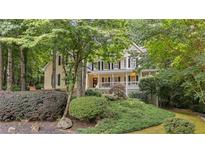 Charming two-story home with a welcoming front porch and beautifully landscaped front yard, surrounded by mature trees at 2722 Brookhaven Ln, Buford, GA 30518