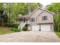 Charming split-level home featuring a welcoming front porch, well-manicured lawn, and a convenient two-car garage at 69 Due West Pass, Dallas, GA 30157