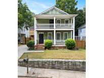 Charming two-story home with a double front porch, green siding, and well-maintained landscaping at 187 Vanira Se Ave, Atlanta, GA 30315