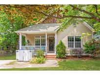 Charming bungalow with a covered porch, landscaped front yard and mature trees at 747 Dill Sw Ave, Atlanta, GA 30310