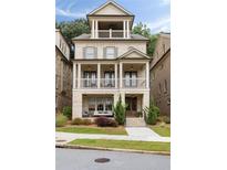 Charming three-story home with a double stacked covered porch, a brick facade, and manicured landscaping at 2110 Timball Nw Rd, Atlanta, GA 30318