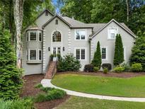 Charming two-story home featuring a manicured lawn, gray stucco, and a welcoming front entrance with manicured landscaping at 1975 River Forest Drive, Marietta, GA 30068