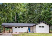 Charming single-story home with a white brick facade, a carport, and a blue front door at 2991 Catalina Dr, Decatur, GA 30032