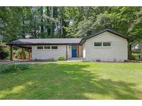 Charming one-story home with painted brick, a manicured lawn, and a welcoming blue front door at 2991 Catalina Dr, Decatur, GA 30032