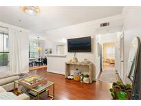Bright living room features hardwood floors, a large television, and a view into dining area at 3777 Peachtree Ne Rd # 1112, Brookhaven, GA 30319
