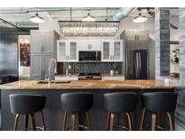 Modern kitchen with quartz countertops, stainless steel appliances, gray cabinets, and stylish pendant lighting at 878 Peachtree St # 601, Atlanta, GA 30309