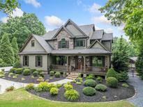 Charming two-story home featuring a welcoming front porch and professional landscaping at 407 Maple Ridge Ct, Cumming, GA 30028