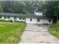 Ranch-style home features a long, single-story layout with a concrete driveway surrounded by trees at 3785 Somerset Sw Dr, Marietta, GA 30064