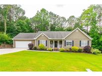 Charming single-story home features a well-manicured lawn and attached two car garage at 2430 Tribble Creek Cv, Grayson, GA 30017