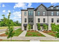 Charming townhomes with modern design elements, including brick facades, black window frames, and well-maintained landscaping at 449 Breccia Run, Mcdonough, GA 30253