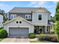 Charming two-story home with a two-car garage, inviting front porch, and landscaped yard at 5730 Arbor Green Cir, Sugar Hill, GA 30518