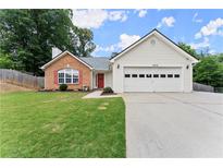 Charming single-story home featuring a brick facade, white siding, and a well-manicured lawn at 2605 Fort Apachee Trl, Dacula, GA 30019