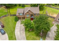 Charming two-story home with a well-maintained front yard, long driveway, and inviting red front door at 2870 Tattersall Ct, Cumming, GA 30041