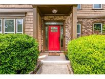Inviting front entrance with a striking red door and stone accents framed by lush greenery at 2870 Tattersall Ct, Cumming, GA 30041