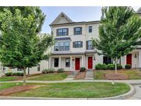 Charming townhome featuring a well-maintained lawn, brick facade, dark shutters and a red front door at 3360 Pickens St, Duluth, GA 30096