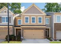 Charming two-story townhome featuring a brick facade and a convenient attached garage for easy parking and storage at 813 Whittington Parkway Sw, Marietta, GA 30060