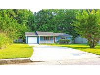 Charming single-story home with a well-manicured lawn, blue siding, and a cozy front porch at 1183 Iron Gate Blvd, Jonesboro, GA 30238