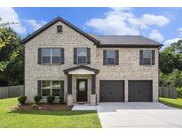 Charming two-story brick home with a two-car garage and well-maintained landscaping at 12225 Anchor Way, Hampton, GA 30228