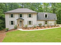 Charming home featuring a well-manicured lawn and lush landscaping, complete with shuttered windows at 4800 Timberland Sw Dr, Mableton, GA 30126
