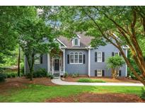 Charming home featuring stone accents, gray siding, lush landscaping and a welcoming front porch at 2045 Bethany Spring Trce, Cumming, GA 30041