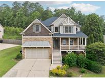 Charming two-story home featuring a stone facade, covered porch, and an attached two-car garage at 402 Homestead Dr, Dallas, GA 30157