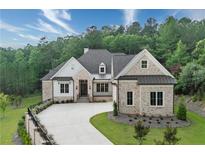 Charming brick and shingle home with well-manicured lawn, long driveway, and lush landscaping at 11 Brownson Ct, Acworth, GA 30101