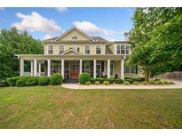 Charming two-story home with a welcoming front porch, lush lawn, and well-maintained landscaping at 360 Glade Knoll Trail Trl, Fayetteville, GA 30215