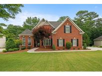 Charming brick two-story home featuring well-manicured lawn and a welcoming front entrance at 1012 Chestnut Creek Dr, Villa Rica, GA 30180