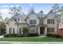 Charming two-story brick home with manicured lawn and lush landscaping at 10565 Highgate Manor Ct, Duluth, GA 30097