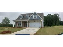 Charming two-story home with a gray brick facade, dormer windows, two-car garage and well-manicured lawn at 5985 Spring Way, Stonecrest, GA 30038