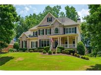 Beautiful brick and siding home featuring a well-manicured lawn and inviting front porch at 6105 Overlook Park Dr, Cumming, GA 30040
