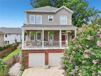 Charming two-story home featuring a welcoming front porch, red door, and a two-car garage at 218 South Se Ave, Atlanta, GA 30315