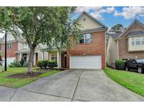 Charming brick-front home with a two-car garage and a well-maintained lawn in a suburban neighborhood at 2280 Copper Trail Ln, Buford, GA 30519