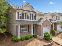 Charming two-story home featuring a brick facade, attached garage, and well-maintained landscaping at 181 Ridgemont Rd, Canton, GA 30114